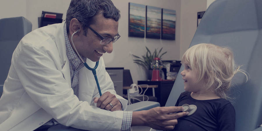 Dr. Akuthota with child patient smiling